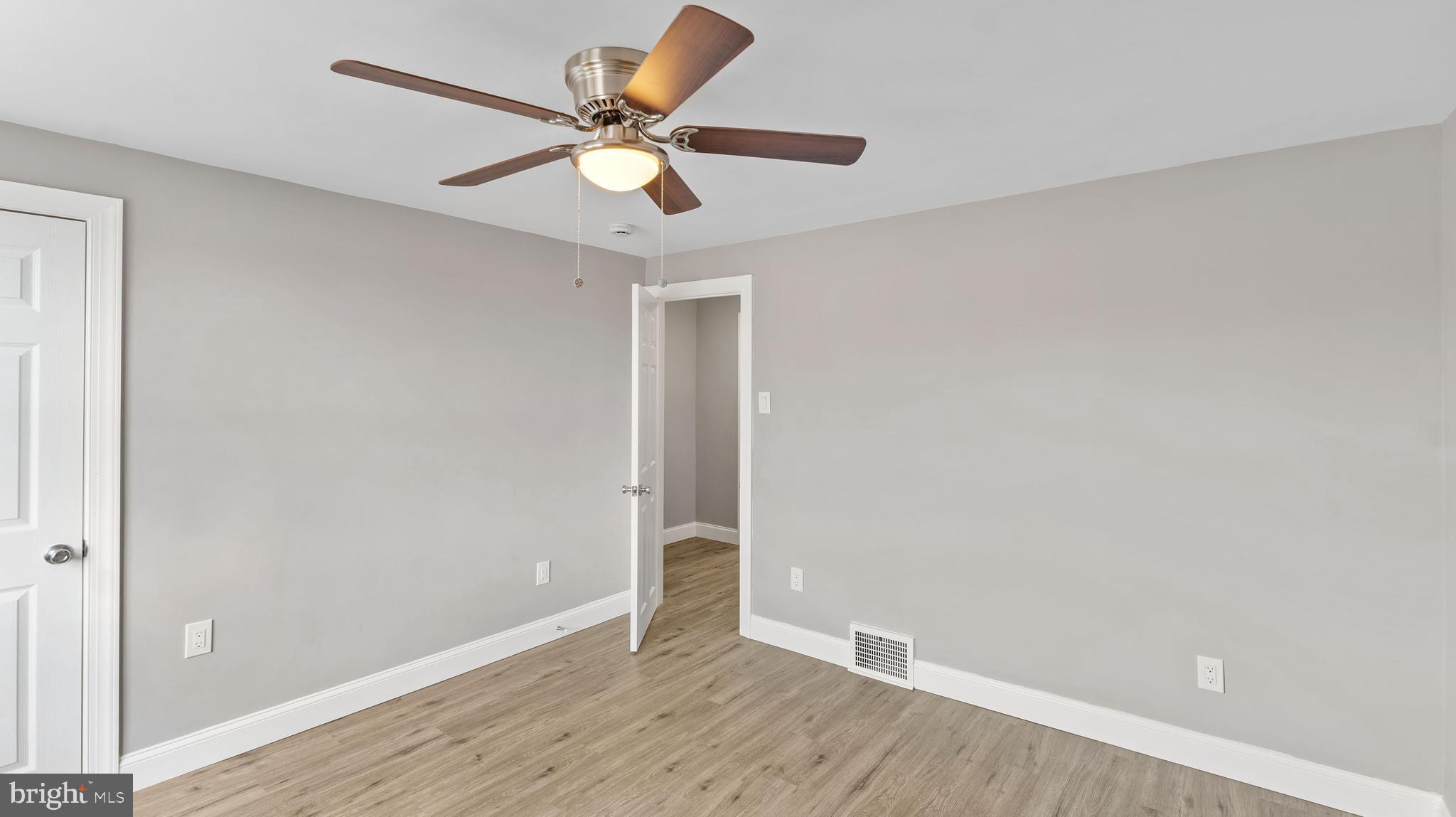 240 Spring Valley Road Darby, PA 19023 - Photo 16 of 24 an empty room with wooden floor and fan