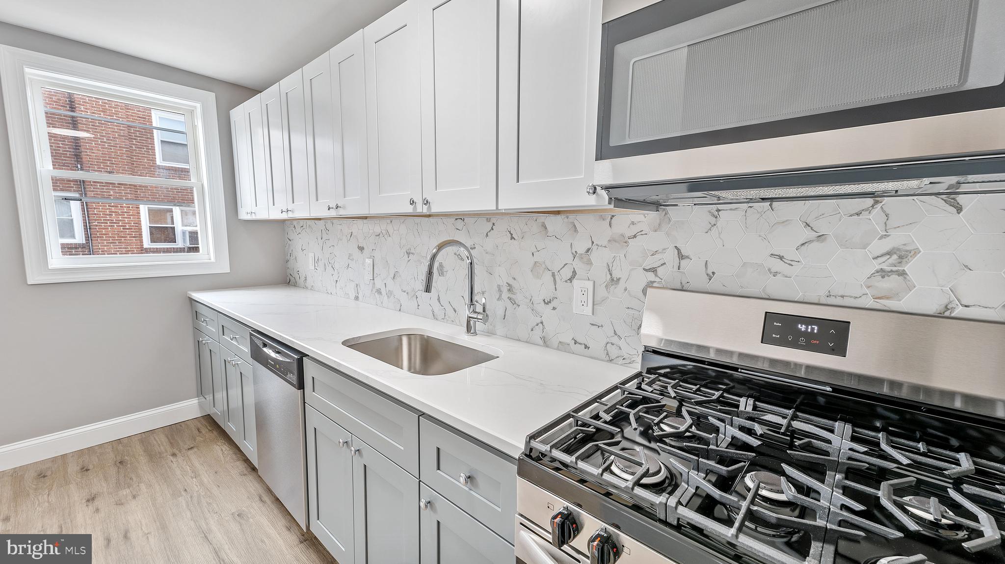 240 Spring Valley Road Darby, PA 19023 - Photo 8 of 24 a kitchen with a sink stove top oven and cabinets