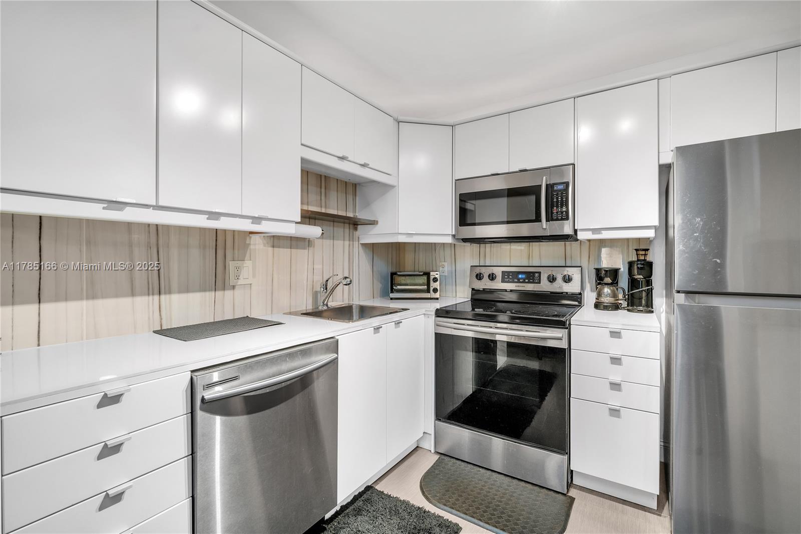 257 South Cypress Road, Unit 416 Pompano Beach, FL 33060 - Photo 1 of 11 a kitchen with a sink stove and refrigerator