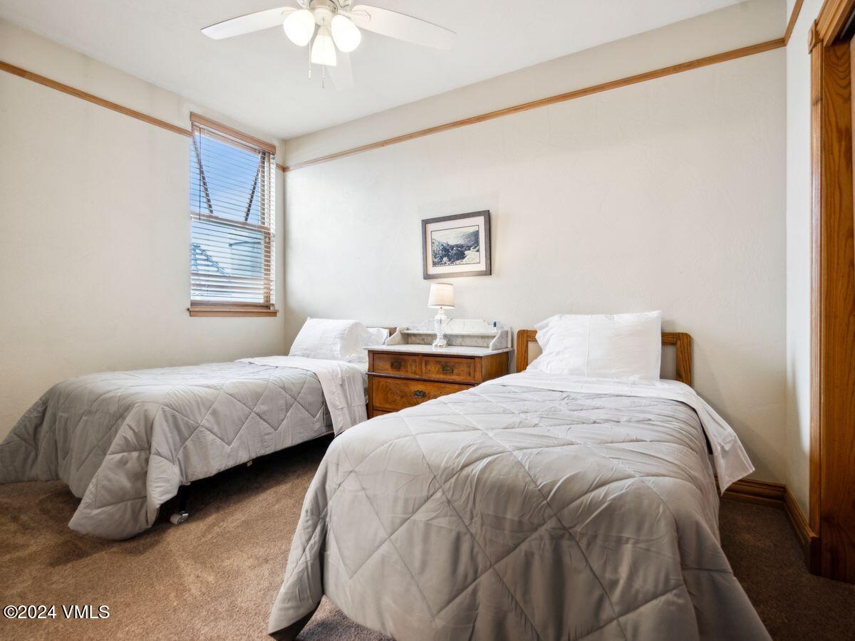 137 Main Street, Unit R203 Edwards, CO 81632 - Photo 25 of 39 a bedroom with two beds and a chandelier