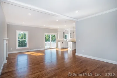 a view of empty room with wooden floor and fireplace
