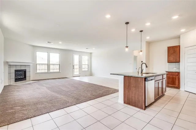 a large kitchen with kitchen island granite countertop a sink a counter top space and cabinets