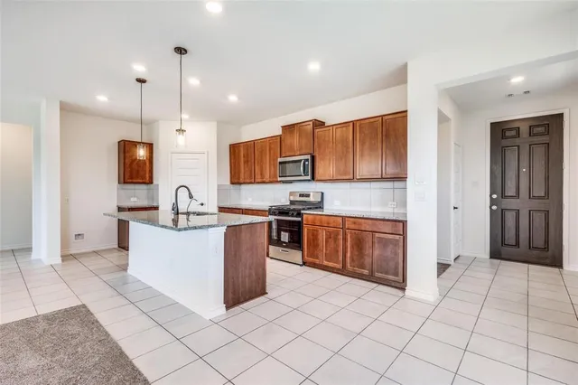 a kitchen with stainless steel appliances granite countertop a refrigerator oven a sink and dishwasher