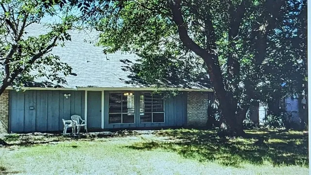 a backyard of a house with table and chairs