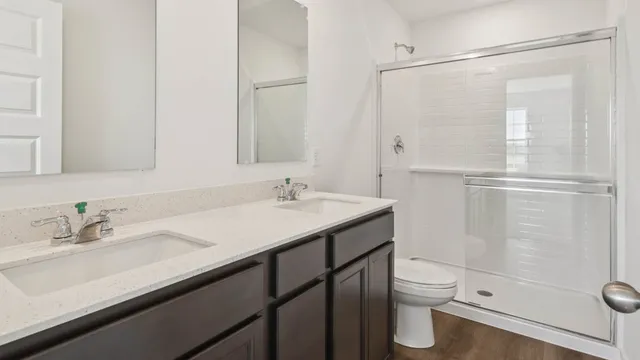 a bathroom with a sink a toilet and shower