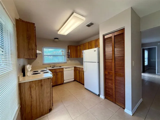 a kitchen with a refrigerator and a stove top oven