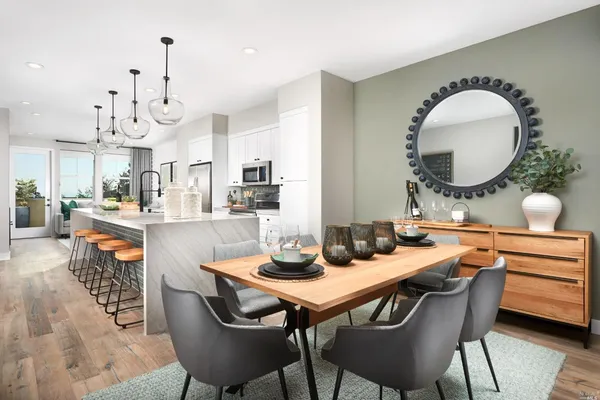 a dining hall with stainless steel appliances kitchen island a table and chairs