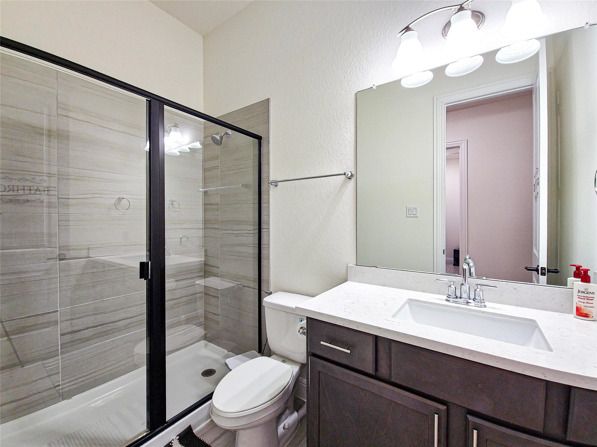813 Sunny Ridge Drive Leander, TX 78641 - Photo 20 of 32 Modern full bathroom features a glass-enclosed shower, sleek vanity, and tiled floors.