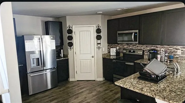 a kitchen with stainless steel appliances granite countertop a refrigerator stove and sink