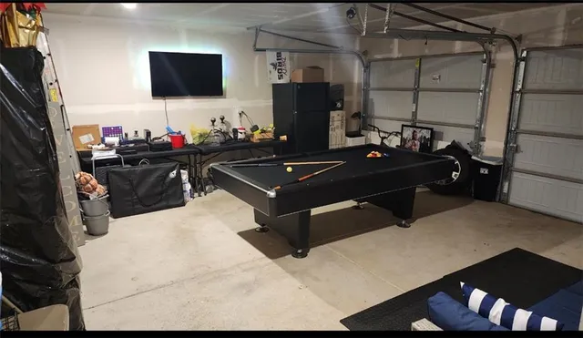 a room with a table chairs and a flat screen tv