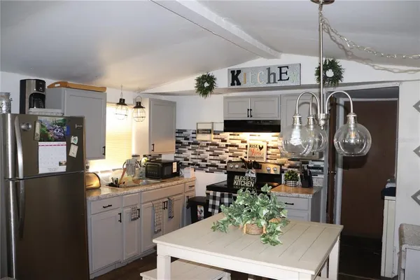 a kitchen with refrigerator and stove