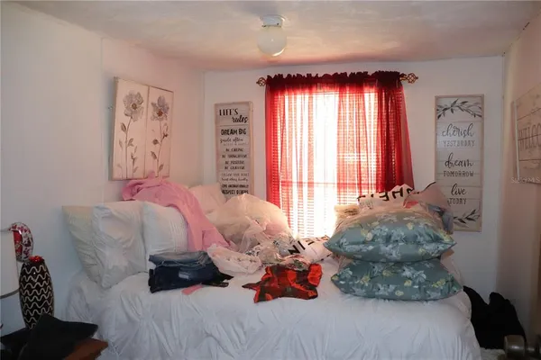 a bed sitting in a bedroom next to a window