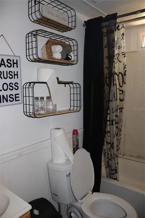 a bathroom with a toilet a sink and a shower curtain