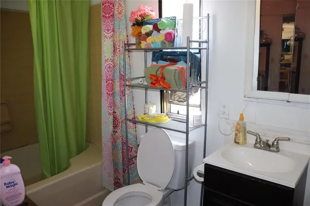 a bathroom with a sink mirror vanity and toilet
