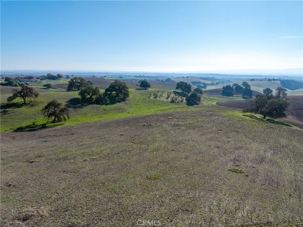 an aerial view of field with ocean view