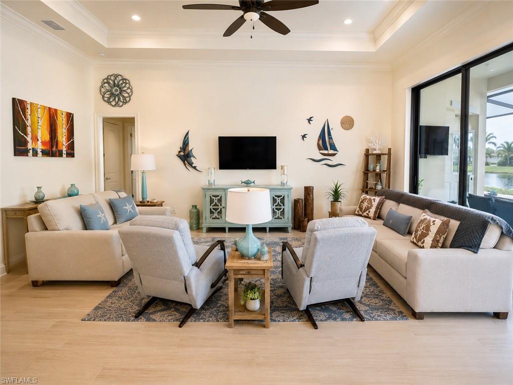 6574 Amarone Lane Naples, FL 34113 - Photo 14 of 44 a living room with furniture and a flat screen tv