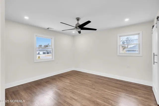 a view of a big room with wooden floor and a chandelier fan