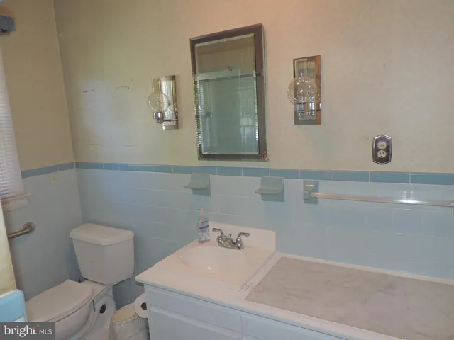 a bathroom with a toilet sink and mirror