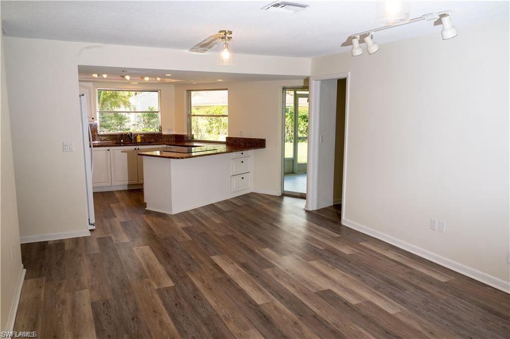 5654 Eichen Circle Fort Myers, FL 33919 - Photo 46 of 47 Kitchen with a peninsula, white cabinetry, dark wood-style flooring, and open floor plan