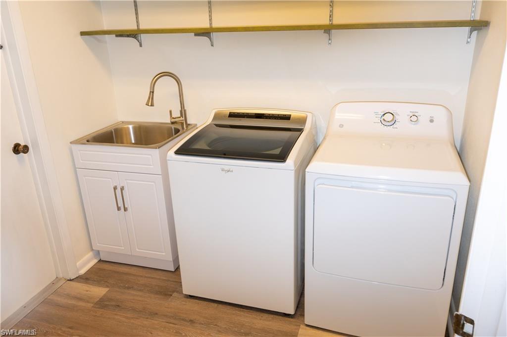 5654 Eichen Circle Fort Myers, FL 33919 - Photo 39 of 47 Laundry area featuring separate washer and dryer, wood finished floors, and cabinet space