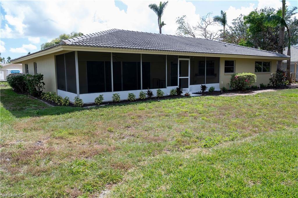 5654 Eichen Circle Fort Myers, FL 33919 - Photo 43 of 47 Rear view of house with a yard, stucco siding, a sunroom, and a tiled roof