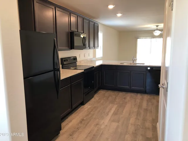 a kitchen with granite countertop stainless steel appliances a refrigerator and a sink