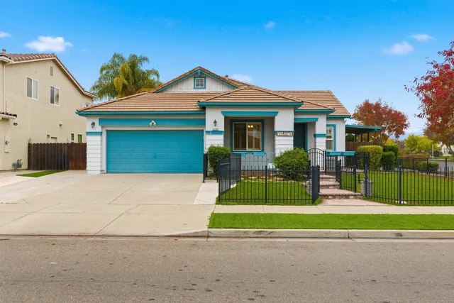a front view of a house with a yard and potted plants