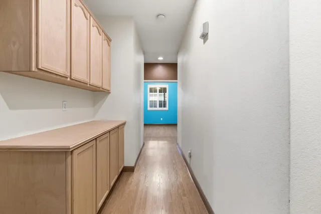 a view of a hallway with wooden floor and staircase