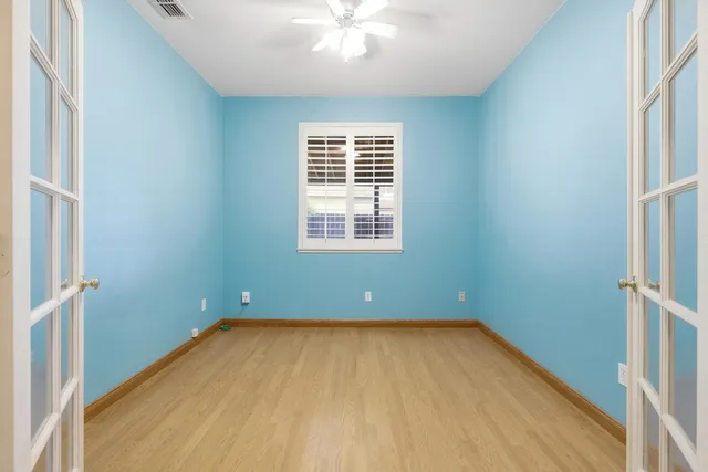 an empty room with a window and a ceiling fan