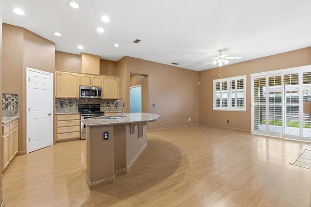 a kitchen with stainless steel appliances granite countertop a stove a sink a refrigerator and a microwave