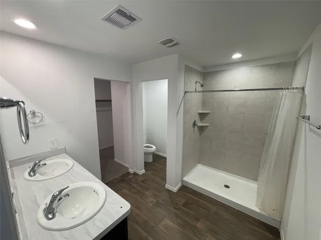 a bathroom with a sink a toilet and shower