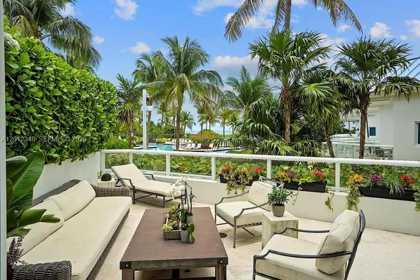 a view of a patio with couches table and chairs and potted plants
