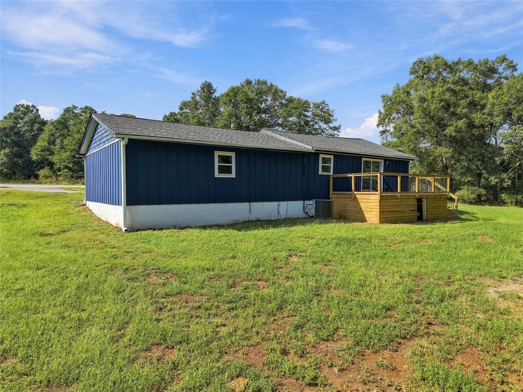 418 Old River Road Pelzer, SC 29669 - Photo 28 of 32 An elevated wooden deck overlooks the grassy yard surrounding this home with board and batten siding.