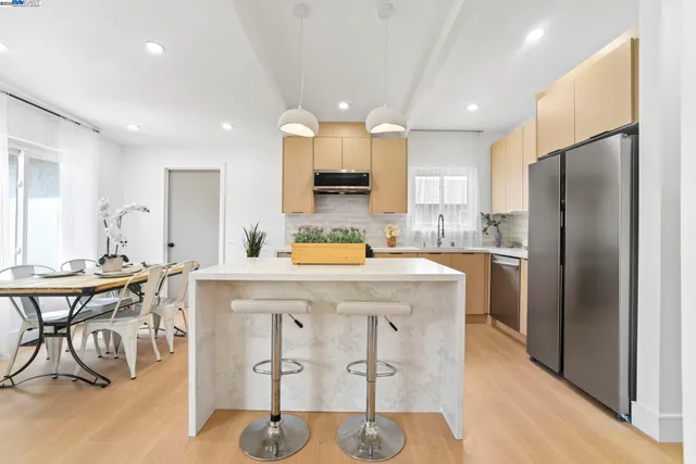 a kitchen with kitchen island granite countertop a sink stove and refrigerator