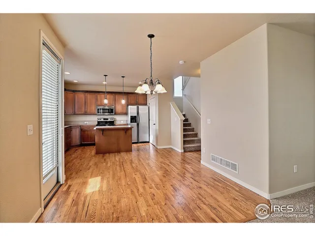 a kitchen with stainless steel appliances granite countertop a sink a stove a refrigerator a center island and cabinets