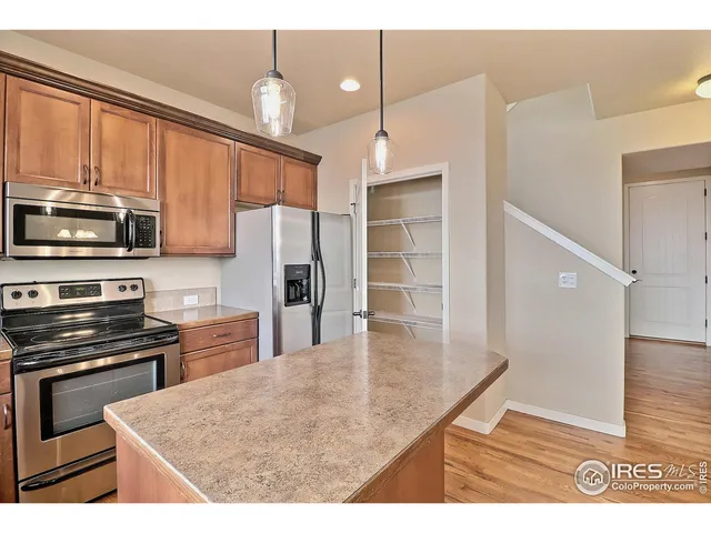 a kitchen with granite countertop a stove top oven microwave and cabinets