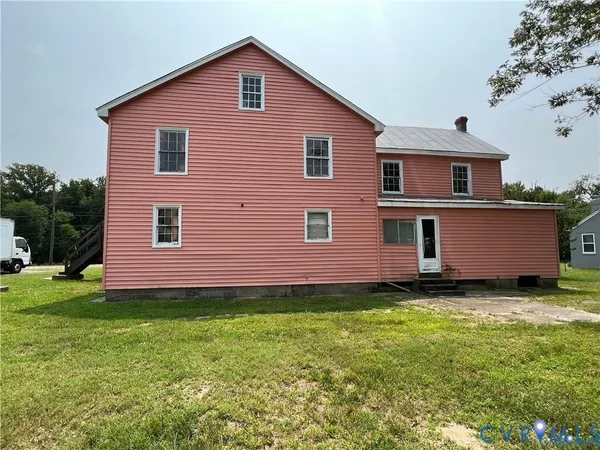 a view of a house with a big yard and large trees