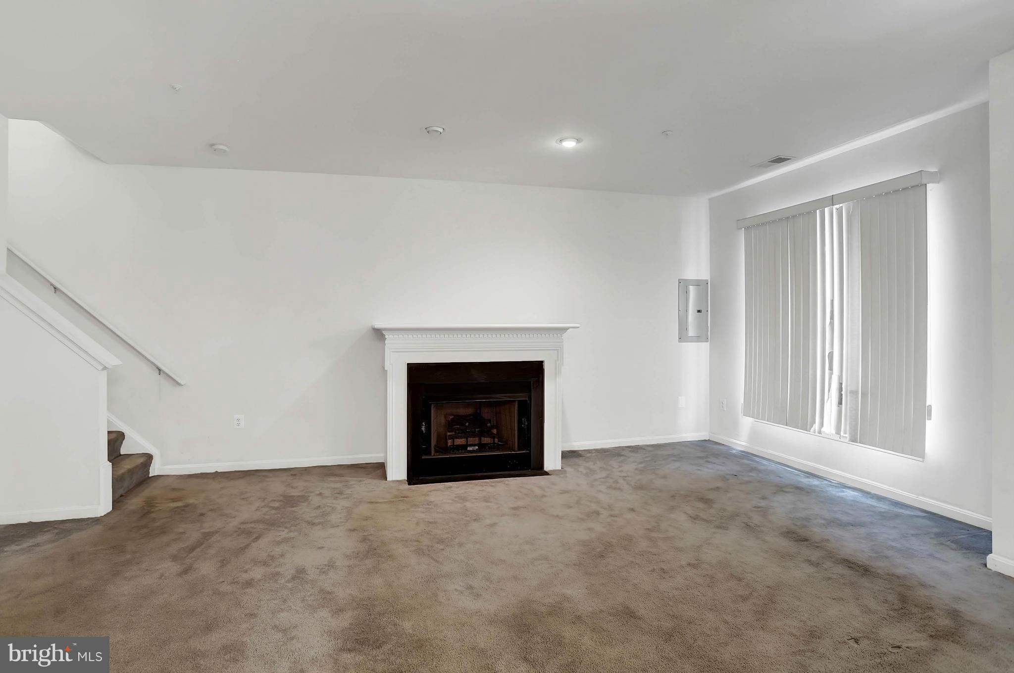 8724 Autumn Ridge Court Odenton, MD 21113 - Photo 4 of 24 a view of an empty room with a fireplace and a window