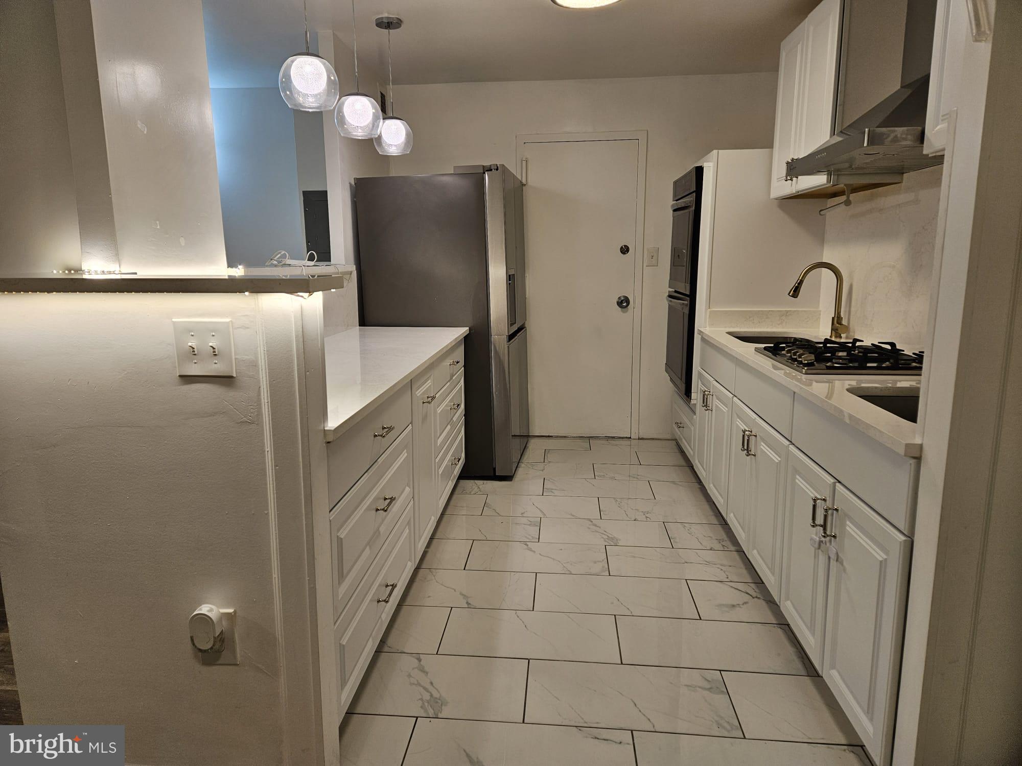 1111 University Boulevard West, Unit 719A Silver Spring, MD 20902 - Photo 7 of 41 a kitchen with cabinets and stainless steel appliances