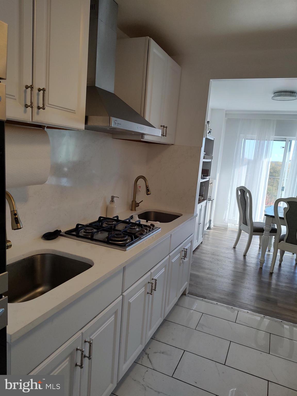 1111 University Boulevard West, Unit 719A Silver Spring, MD 20902 - Photo 8 of 41 a kitchen with granite countertop a sink a stove and cabinets