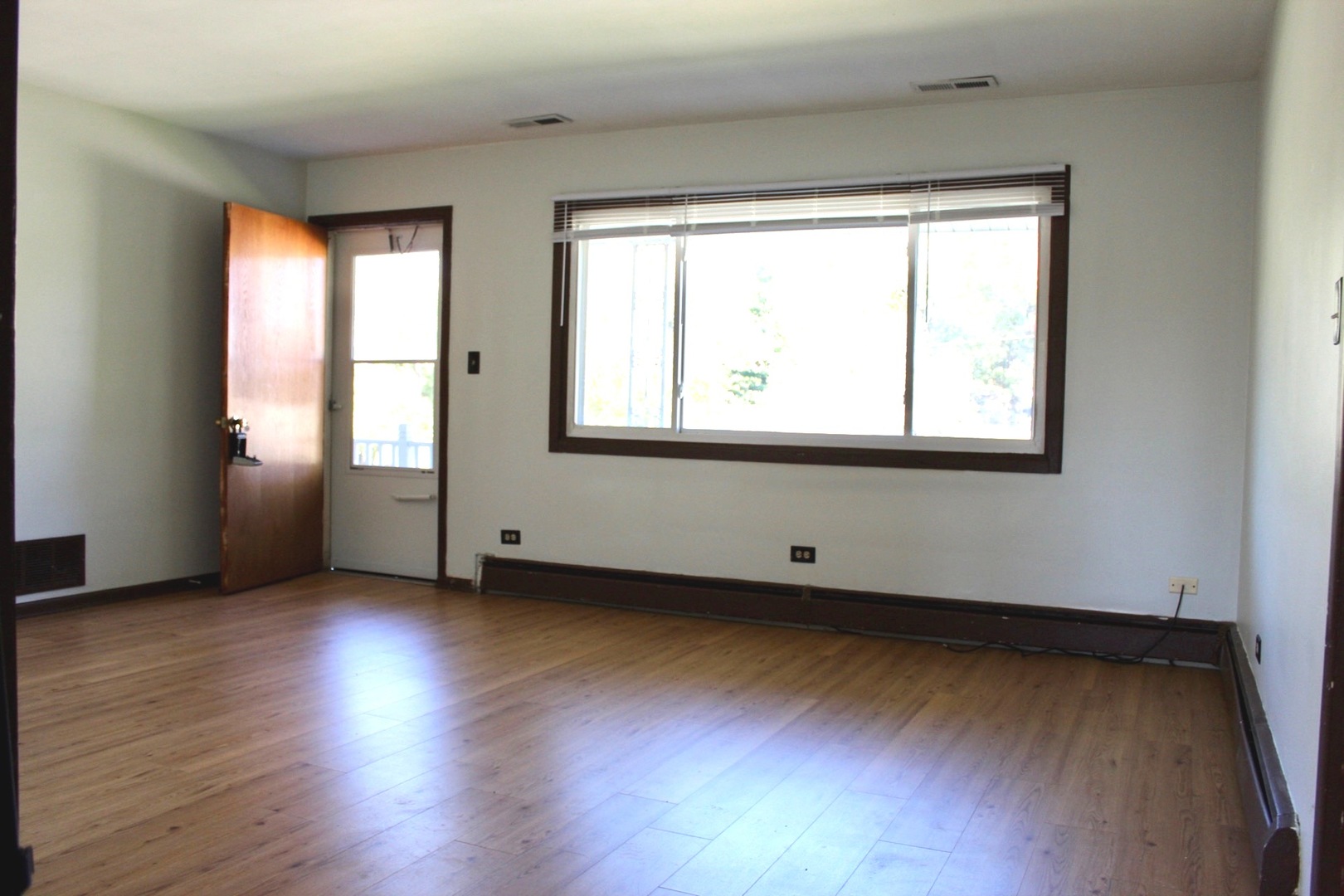 321 South Avenue, Unit C Hampshire, IL 60140 - Photo 5 of 15 an empty room with wooden floor and windows