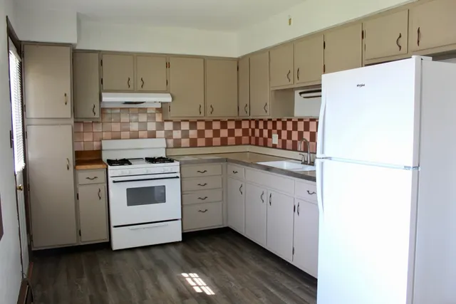 a kitchen with white cabinets and white appliances