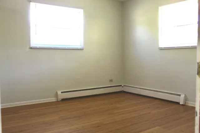 a view of a room with wooden floor and a window
