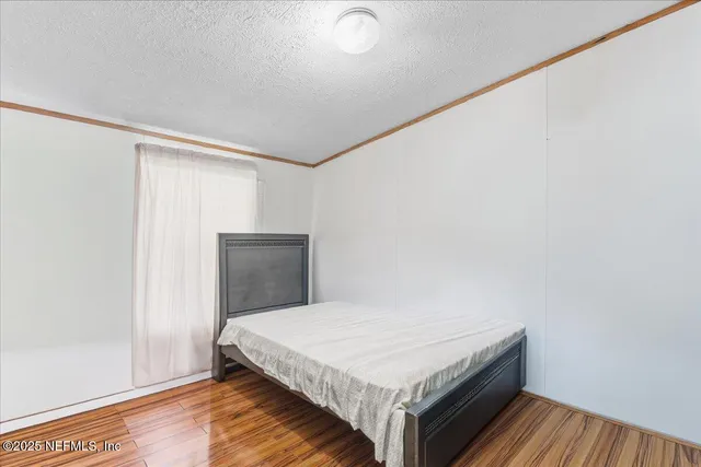 a bedroom with a bed and wooden floor