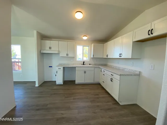 a kitchen that has a sink a stove and cabinets