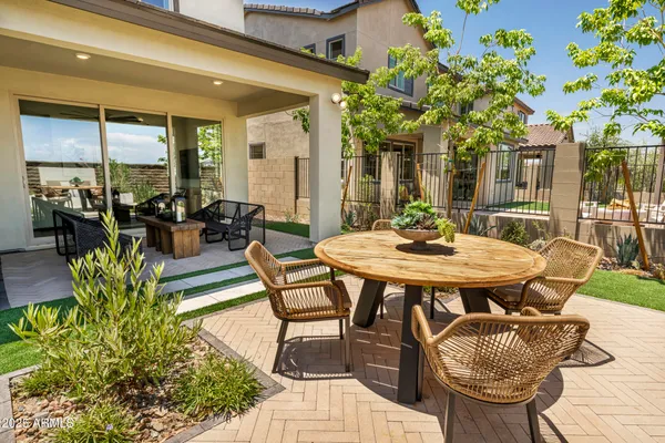 a view of a patio with a dining table and chairs with potted plants