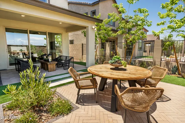 a view of a patio with a dining table and chairs with potted plants
