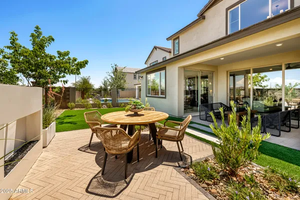 a view of a patio with table and chairs potted plants with wooden fence