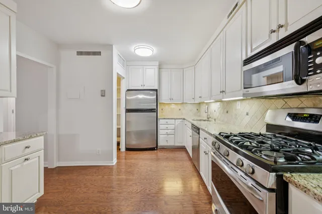 a kitchen with stainless steel appliances granite countertop a stove and a refrigerator