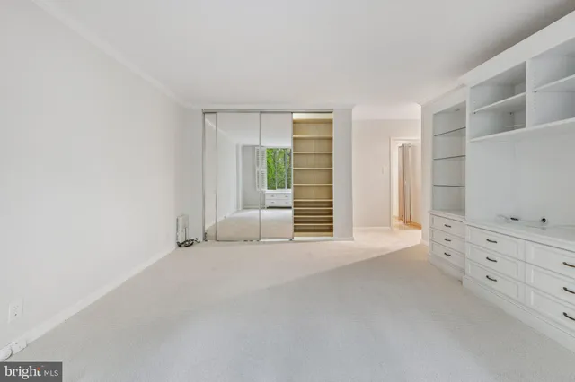 an empty room with cabinet and mirrors